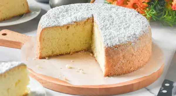Un delicioso pa de pessic, esponjoso y cubierto de azúcar glas, listo para ser disfrutado.