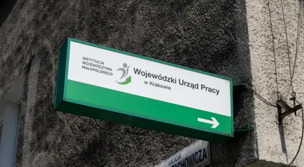 Tablica z napisem "Wojewódzki Urząd Pracy w Krakowie" i strzałką.