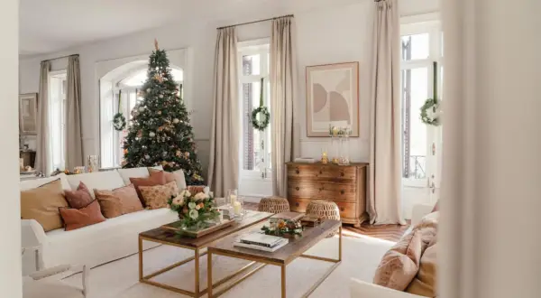Un salón acogedor con un árbol de Navidad decorado, sofás cómodos y mesas de centro de madera. Es la casa de navidad de el mueble, lista para celebrar.