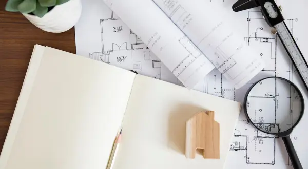 Uproszczony wypis z rejestru gruntów, plany architektoniczne, lupa i drewniany domek.