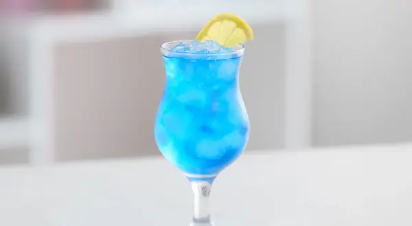 Erfrischender Blue Lagoon Cocktail mit Eis und Zitronenscheibe. Perfekt für dein Blue Lagoon Cocktail Rezept.