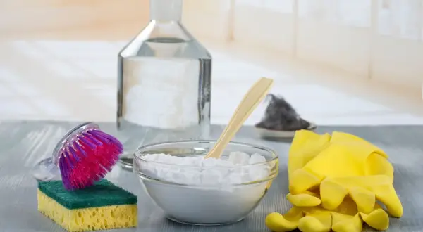 Ecco gli ingredienti per capire come togliere lo sporco dalla pelle: bicarbonato, aceto, spazzola, spugna e guanti gialli.