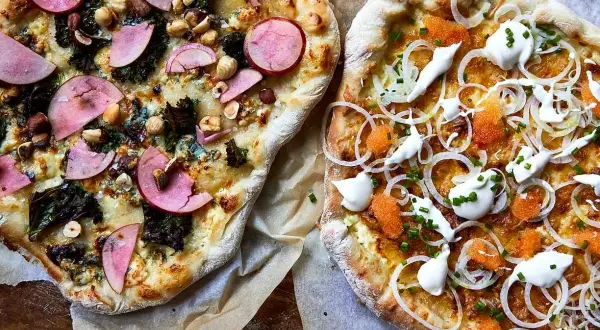 Två läckra pizzor, en med äpple och nötter, den andra en vit pizza med rom och gräddfil.