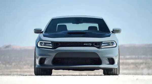 Szary Dodge Charger Hellcat z czarną maską i reflektorami LED na pustynnym tle.
