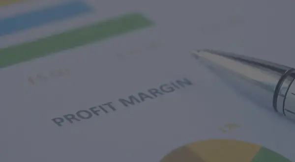 Długopis na dokumencie z wykresem i tekstem "PROFIT MARGIN". Analiza danych, jak obliczyć marżę, by zwiększyć zyski.