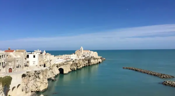 La piana della battaglia di Vieste, con le sue case bianche aggrappate alla roccia, si affaccia sul mare azzurro.