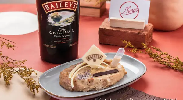 Torrijas de Baileys, un postre cremoso con un toque de licor irlandés, decorado con chocolate y una pipeta de salsa.