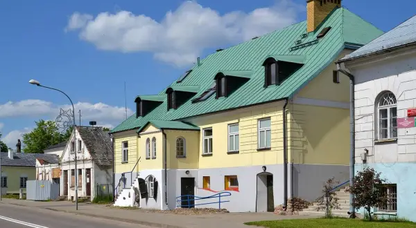 Kolorowe kamienice w Sejnach, z zielonymi dachami i licznymi oknami, tworzą urokliwy krajobraz. To jedne z wielu atrakcji Sejn.
