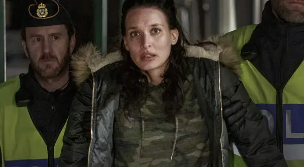 En kvinna omgiven av poliser i en dramatisk scen från en norsk serie på SVT.