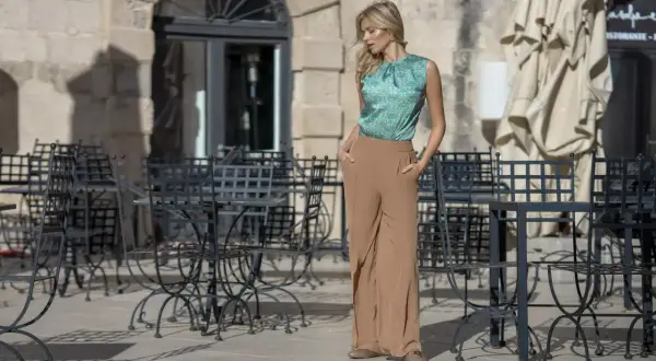 Elegancka stylizacja na wieczór panieński: zielona bluzka w delikatny wzór i beżowe, szerokie spodnie. Idealna na letnie wyjście.