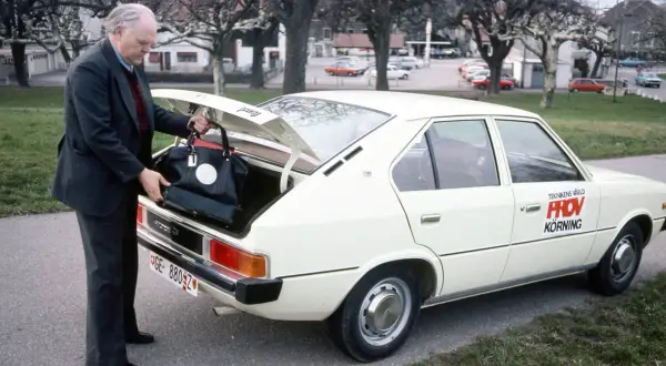 Äldre man lastar bagage i en vit Hyundai Pony. Bilen har texten "Teknikens Värld Provkörning" på sidan.