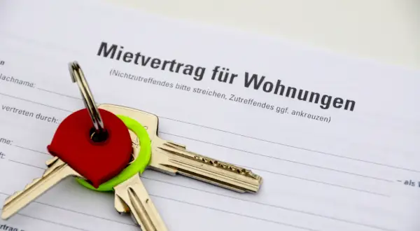 Schlüssel auf einem Mietvertrag. Der Vertrag ist für Wohnungen in Hamburg, und die Schlüssel symbolisieren den Einzug in ein neues Zuhause, vielleicht nach Prüfung des Betriebskostenspiegels Hamburg.
