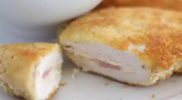 Un délicieux cordon bleu, pané et doré, révèle son cœur fondant de jambon et de fromage. Servi avec une salade verte.