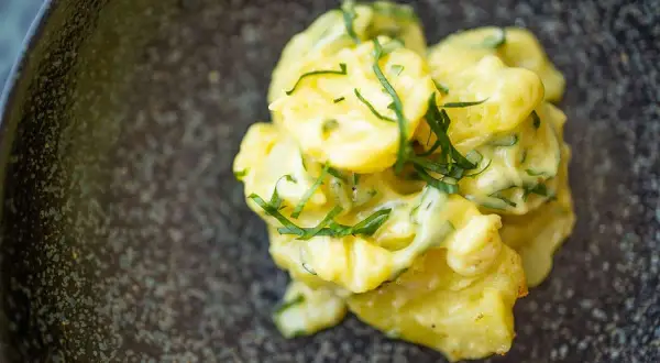 Cremiger Kartoffelsalat mit Mayonnaise und frischen Kräutern, ein köstliches Rezept für jede Gelegenheit.