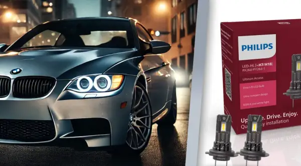 Srebrne auto z włączonymi światłami LED na tle miasta. Obok opakowanie żarówek Philips Ultinon Access, które jakie żarówki odmienią nocną jazdę.