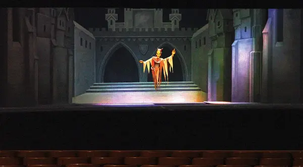 Eine gruselige Figur steht auf der Bühne von Gerhards Marionettentheater vor einer Burgkulisse.