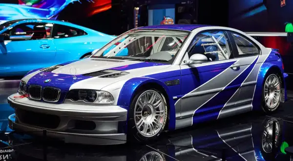 Wyścigowe BMW M3 GTR w niebiesko-srebrnym malowaniu, gotowe do akcji.