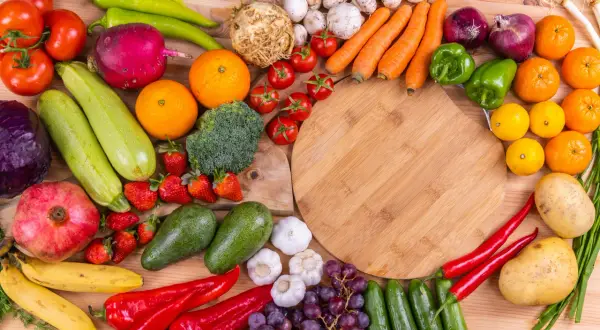 En färgsprakande samling frukter och grönsaker, som paprika, tomater, apelsiner och jordgubbar, som kan hjälpa mot c vitamin brist.