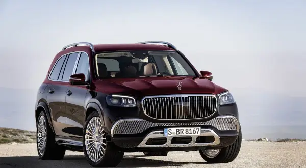 Luksusowy, bordowy GLS Maybach z chromowanymi felgami stoi na pustkowiu, gotowy na każdą podróż.