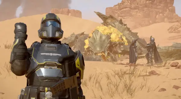 Helldivers 2 crossplay: żołnierze w pancerzach walczą z potworem na pustyni.