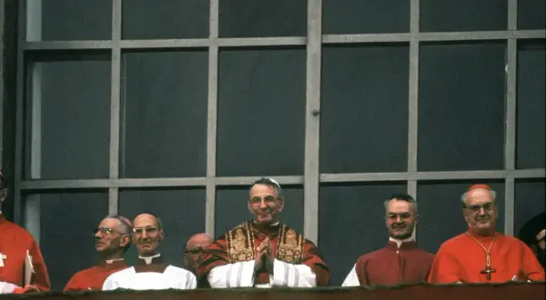 Uroczyste zgromadzenie duchownych, wśród nich papież Jan Paweł II. Wszyscy w strojach liturgicznych, przypominają o ważnych imionach papieży.