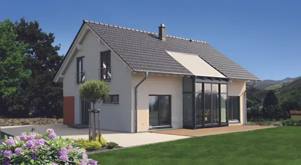 Modernes 1,5-geschossiges Haus mit Satteldach und Glasanbau. Der Grundriss bietet viel Licht und Raum.