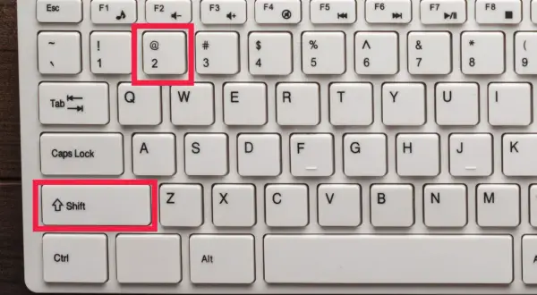 Klawiatura z podświetlonym klawiszem "@" (małpa znak) i klawiszem Shift.