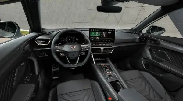 Interni sportivi e moderni della Cupra Formentor: volante con logo, ampio display centrale e sedili in pelle con cuciture a contrasto.