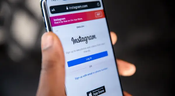 Ktoś trzyma smartfon z otwartą stroną logowania do Instagrama. Czy ktoś widzi, jak oglądam relacje na Instagramie?