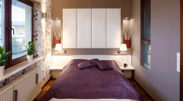 Camera da letto singola con letto matrimoniale, copriletto viola, testiera imbottita bianca e decorazioni moderne. Ideale per chi cerca idee per misure camera da letto singola.