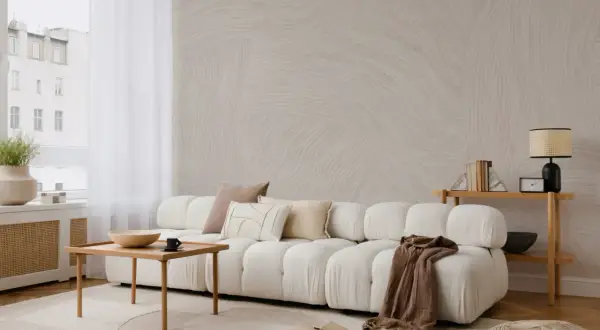 A serene japandi style home living room with a plush white sofa, wooden coffee table, and textured wallpaper.