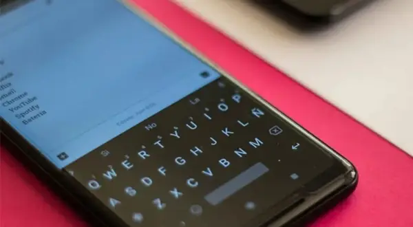 Pantalla de un smartphone con teclado QWERTY. Se busca cómo quitar vibración teclado para una experiencia más silenciosa.