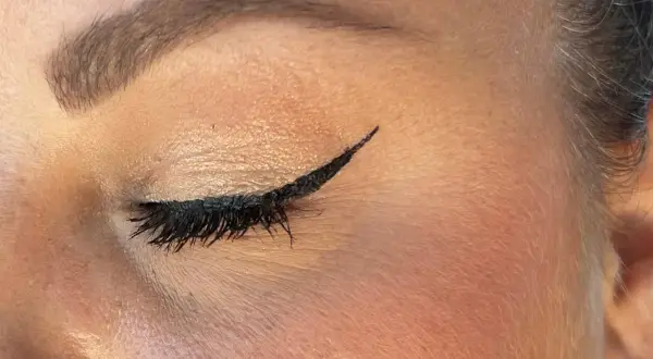 Un trait d'eyeliner noir précis, parfait pour un tuto eyeliner débutant. Cils longs et maquillage des paupières subtil.