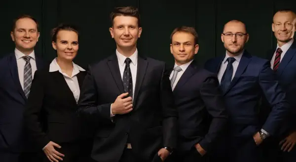 Grupa sześciu profesjonalistów w garniturach, stojących obok siebie.