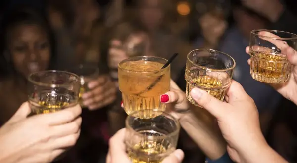 Grupa ludzi wznosi toasty. Trudno ocenić ile alkoholu we krwi, ale zabawa trwa.