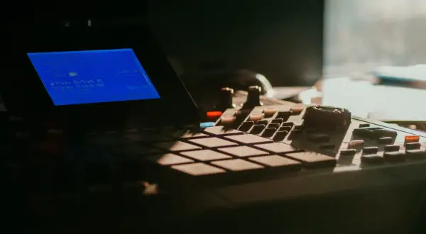 Na ekranie urządzenia widoczna jest tabela strojenia perkusji, z informacjami o ścieżce i programie.