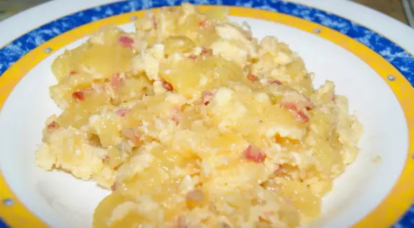 Patatas revueltas con huevo y trocitos de bacon, un plato casero delicioso y reconfortante.