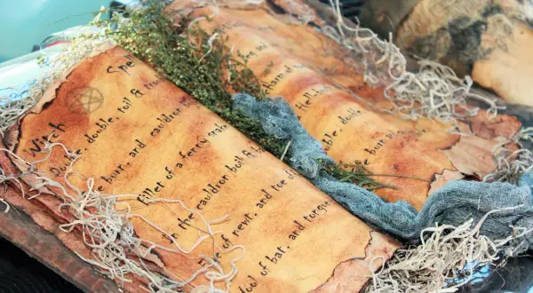 Stara księga zaklęć, ozdobiona gałązkami i sznurkami, przywołuje ducha dawnej **mitologii** i magii.