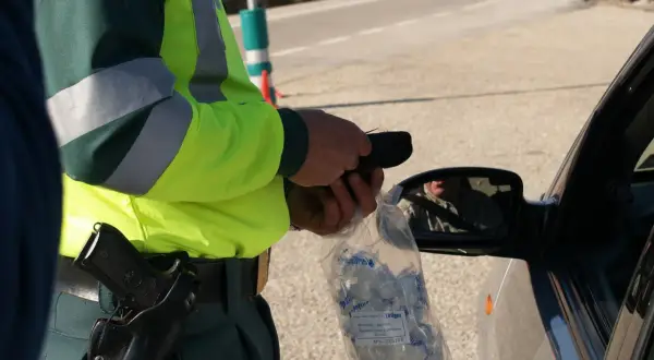 Policjant w kamizelce odblaskowej przeprowadza rutynową kontrolę trzeźwości. Podstawa prawna to bezpieczeństwo na drogach.
