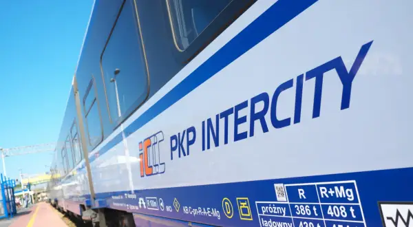 Biało-niebieski pociąg PKP Intercity na tle błękitnego nieba. Idealny na letnie podróże i promocje Intercity.