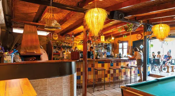 Bar acogedor con techo de paja, horno de leña y una mesa de billar. Ideal para disfrutar de un café moka en San José.