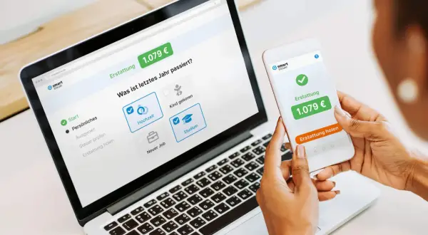 Eine Person nutzt smartsteuer auf Laptop und Smartphone. Die gute smartsteuer erfahrung zeigt eine Erstattung von 1.079 €.