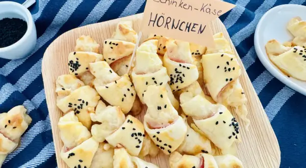 Schinken-Käse-Hörnchen, perfekt für ein karneval buffet kinder. Goldbraun gebacken, bestreut mit schwarzen Sesamkörnern.