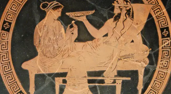 Scène antique : une femme, peut-être la femme d'Hadès, offre une coupe à un homme barbu.