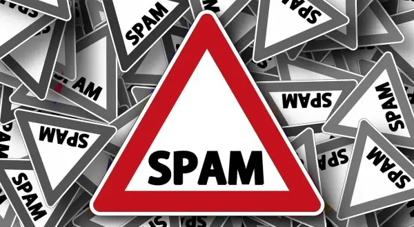 Mnóstwo znaków ostrzegawczych "SPAM" symbolizuje potrzebę ochrony przed niechcianymi wiadomościami.