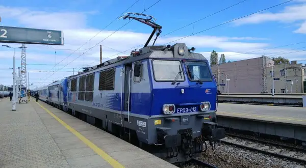 Niebieska lokomotywa PKP Intercity EP09-012 na torze, gotowa do podróży z Olsztyna do Wrocławia.