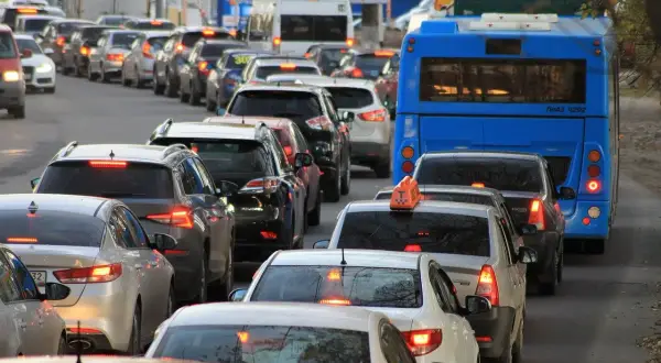 Korek w ruchu drogowym z niebieskim autobusem i wieloma samochodami.