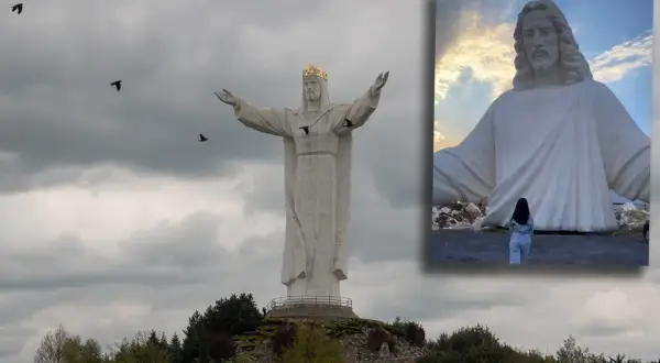 Największy pomnik Jezusa na świecie, z koroną na głowie i rozłożonymi ramionami, majestatycznie góruje nad krajobrazem.