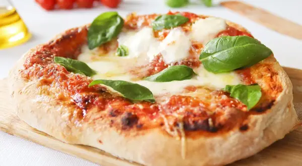Pizza napolitana casera, con tomate, mozzarella fundida y albahaca fresca. ¡Una delicia para tu receta!