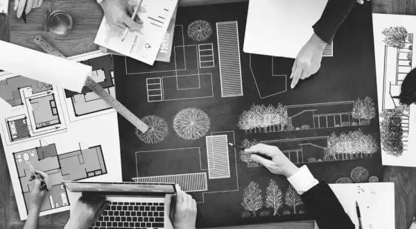 Zespół dyskutuje nad projektem architektonicznym, planując przestrzeń. To kluczowy etap reformy planowania przestrzennego.